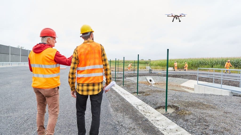 site inspectors measuring construction site using drones